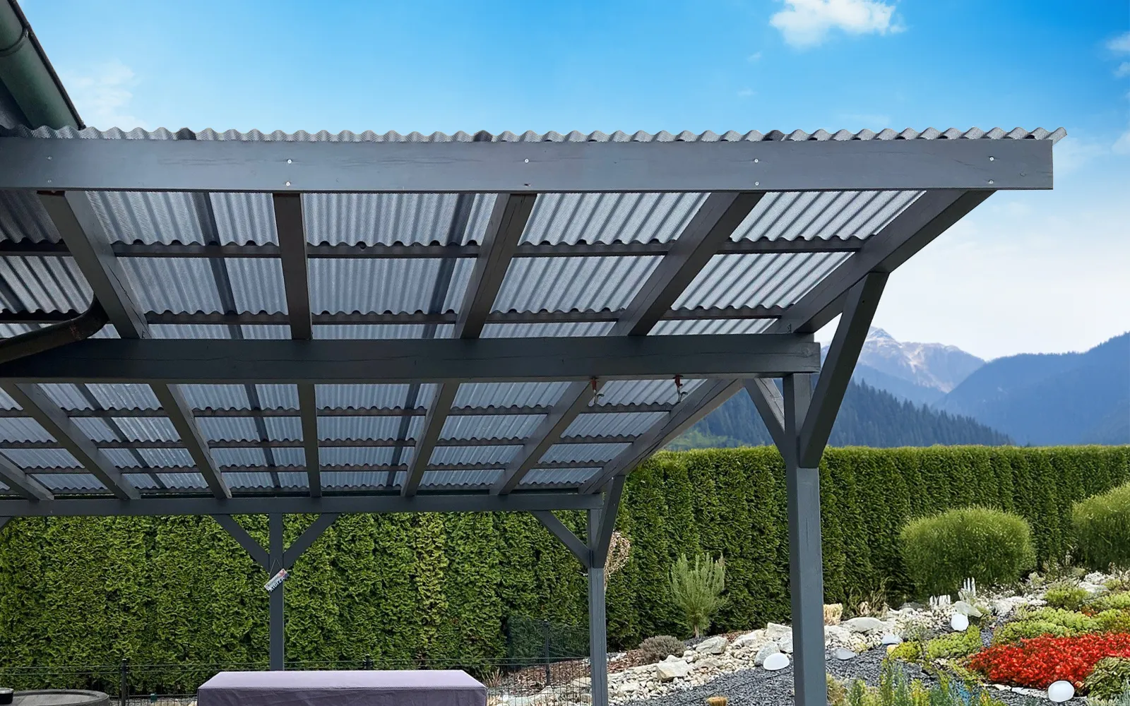 Referenz eines Terrassendaches mit anthrazit grauen Wellplatten